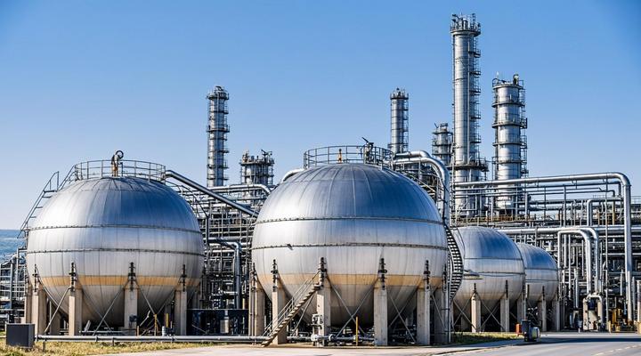 Современный завод по производству биотоплива с блестящими стальными резервуарами, трубами и перегонными колоннами.